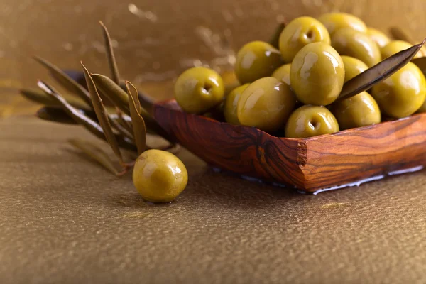 Πράσινες ελιές σε ξύλινο πιάτο — Φωτογραφία Αρχείου