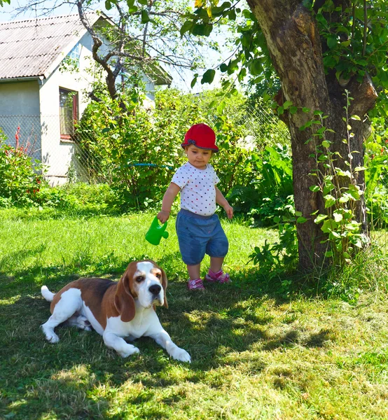 Menina brincando com o cão no jardim — Fotografia de Stock