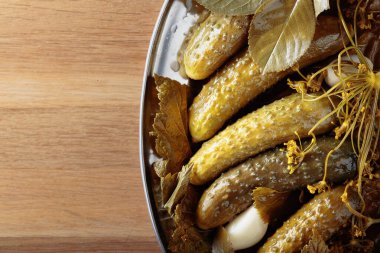 Ev yapımı salatalık turşusu ve sarımsak, dereotu ve yaban turpu. Ahşap arkaplan, kopyalama alanı.