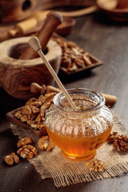 Sağlıklı kahvaltı geçmişi. Bal ve ceviz eski ahşap bir masada.