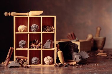 Çikolatalı trüf, kırık çikolata ve baharatlı. Çikolata, tarçın çubukları, anason ve kahve çekirdekleri tahta kutuda..