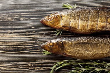 Eski ahşap bir masada tütsülenmiş ringa balığı. Baltık ülkelerinde geleneksel yiyecekler. Üst görünüm.