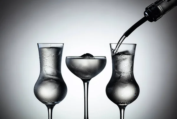 伏特加从瓶子中倒入冰封的玻璃杯中 — 图库照片