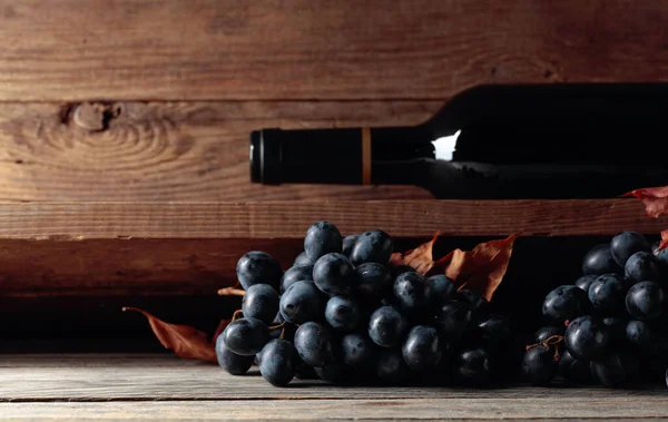 Eine Flasche Rotwein Und Eine Traube Auf Einem Alten Holztisch — Stockfoto