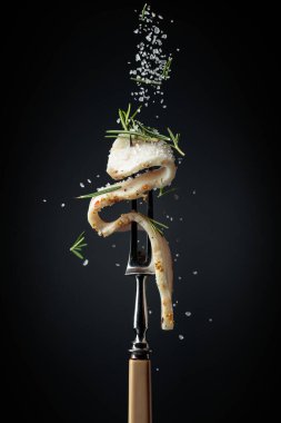 Tuz ve biberiye serpilmiş baharatlı domuz yağı dilimi. Siyah arka planda biberiyeli domuz yağı..