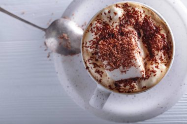 Beyaz ahşap masaya çikolata parçacıkları serpiştirilmiş sıcak çikolata ve lokum. Boşluğu kopyala, üst görünüm .