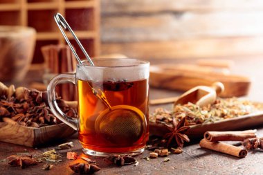 Tarçınlı, anasonlu ve kurutulmuş otlu Noel çayı. Eski kahverengi bir masada, ahşap tabaklarda baharatlı bitki çayı..