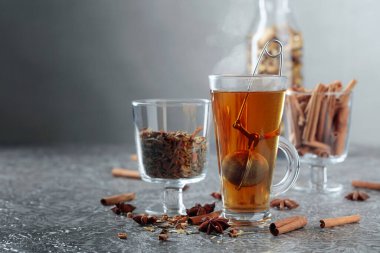 Tarçınlı, anasonlu ve kurutulmuş otlu Noel çayı. Gri arkaplanlı baharatlı bitki çayı..