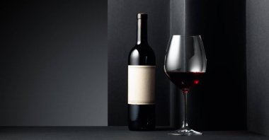 Siyah arka planda kırmızı şarap. Eski boş bir şişede. Boşluğu kopyala.