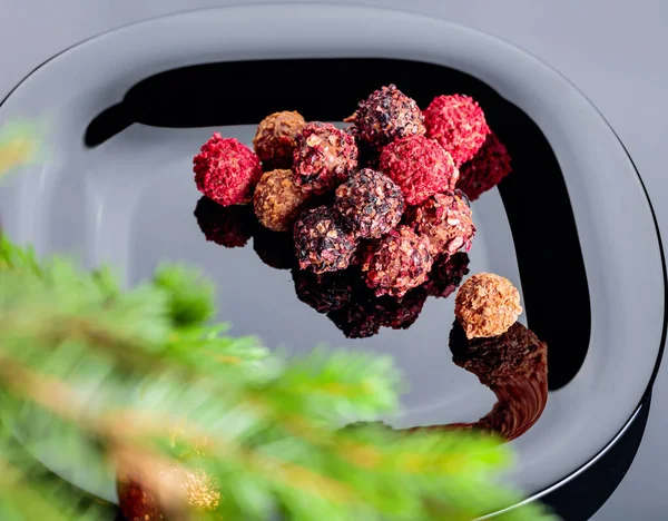 ブラックプレートやクリスマスツリー上の様々なチョコレートトリュフ 選択的焦点 — ストック写真