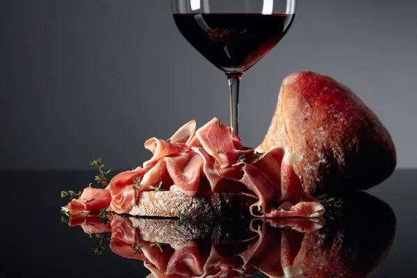 Prosciutto Com Ciabatta Vinho Tinto Tomilho Sobre Fundo Reflexivo Preto — Fotografia de Stock