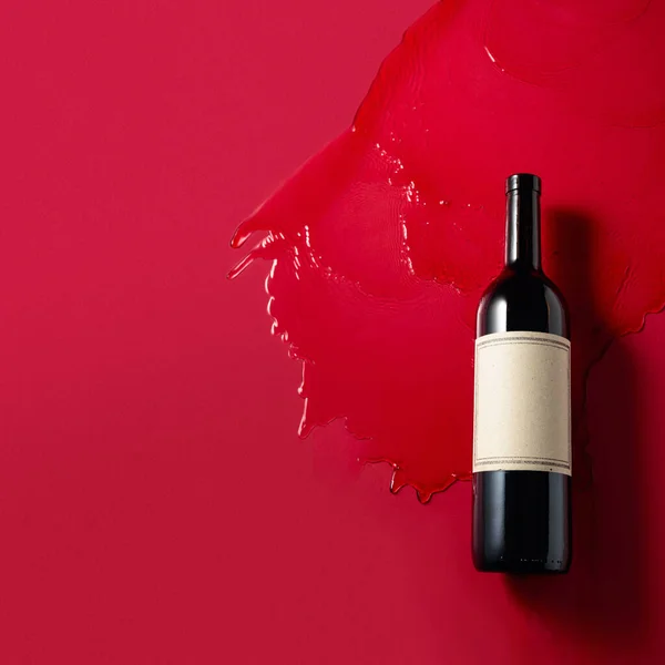 Bottiglia Vino Rosso Con Spruzzi Fondo Rosso Vecchia Etichetta Vuota — Foto Stock