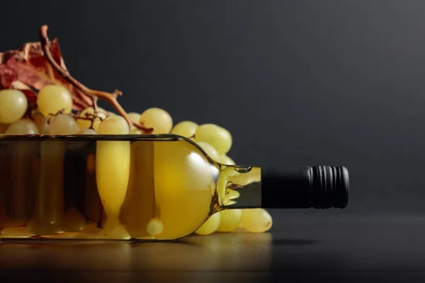 Dojrzałe Winogrona Wysuszonymi Liśćmi Zamkniętą Butelką Białego Wina Czarnym Stole — Zdjęcie stockowe