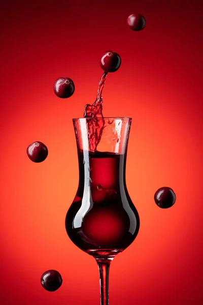 Tranbär Sprit Röd Bakgrund Bär Faller Ett Glas Med Drink — Stockfoto
