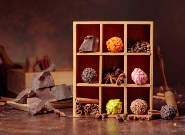 Çikolatalı trüf, kırık çikolata ve baharatlı. Çikolata, tarçın çubukları, anason ve kahve çekirdekleri tahta kutuda..