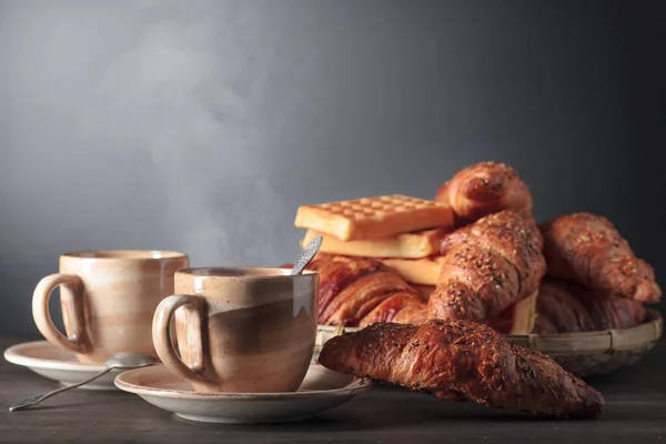 キッチンテーブルの上で黒コーヒーと新鮮なペストリーで朝食 新鮮なワッフルとゴマとクロワッサン スペースのコピー — ストック写真