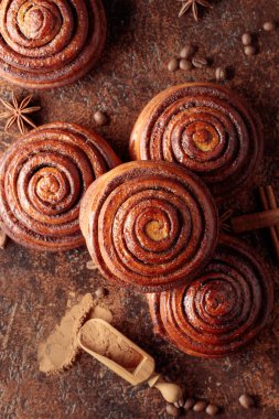 Mutfak masasında taze pişmiş tarçınlı çörekler. Üst görünüm.