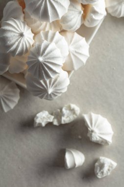 Masanın üzerinde beyaz bir tabakta küçük beyaz kremalar.