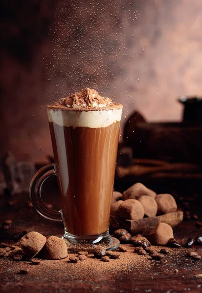 一杯热巧克力与奶油和松露在一个旧的棕色桌子上 洒有可可粉的糖果和饮料 — 图库照片