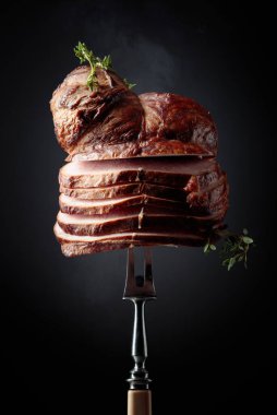 Çatal üzerinde kekik dalları olan dilimlenmiş bir tavla. Geleneksel yöntemlerle üretilen organik bir çiftliğin doğal ürünü..