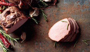 Mutfak masasında biberiyeli, sarımsaklı ve biberli füme jambon..