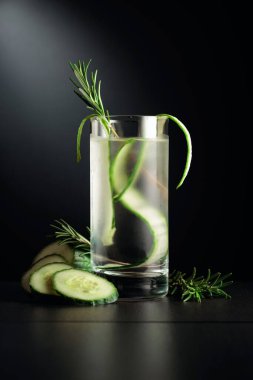 Buzlu, salatalıklı ve biberiyeli soğuk bir içecek. Siyah bir masanın üzerindeki donmuş cam..