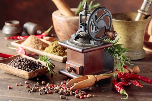 木製のテーブルの上にキッチン用品 スパイスやローズマリーと古いコショウ工場 — ストック写真