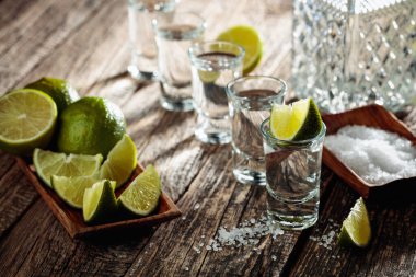 Eski ahşap bir masada tuz ve limon dilimli tekila..