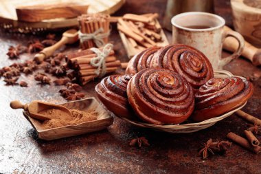 Freshly baked sweet cinnamon buns on a kitchen table.  clipart
