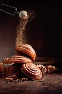 Tarçın tozu serpilmiş taze pişmiş tatlı çörekler. Boşluğu kopyala.