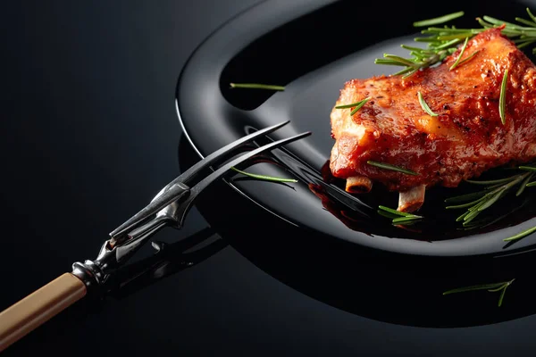 黒いプレートの上に豚カルビを焼きます 黒い背景にローズマリーを振りかけた焼き肉 — ストック写真