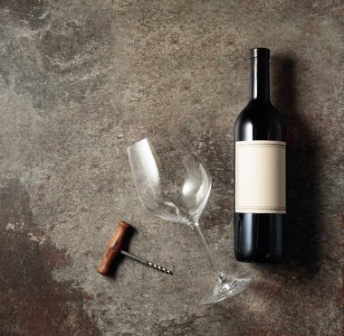 Eski kaba bir arka planda kırmızı şarap. Eski, boş etiketli bir şişe. Üst görünüm.