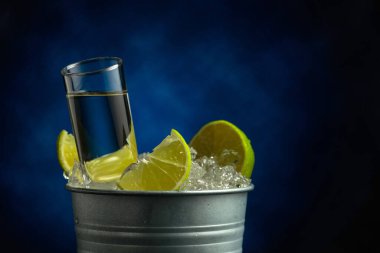 Limon dilimli, buzlu metal kovada güçlü bir alkollü içecek.. 