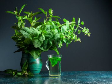 Nane çayı ve eski bir seramik demlikte bir demet taze nane. Boşluğu kopyala.