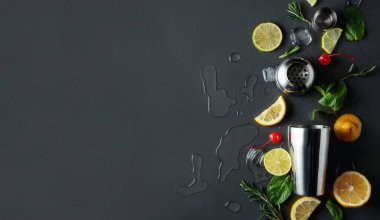 Kokteyl yapmak için malzemelerle karıştırıcı. Kopyalama alanı olan karanlık bir arkaplan. Üst görünüm.