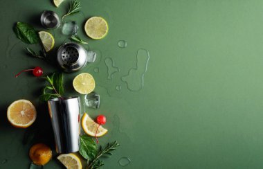 Kokteyl yapmak için malzemelerle karıştırıcı. Kopyalama alanı olan yeşil arkaplan. Üst görünüm.