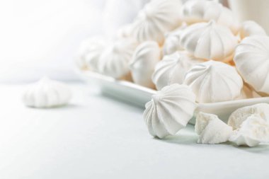 Beyaz bir tabakta küçük beyaz kremalar. Makro atış. Boşluğu kopyala.