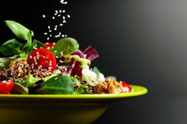 Yeşil salata, domates, ceviz ve susamlı sebze yağı. Boşluğu kopyala.