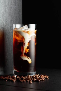 Kremalı buzlu kahve, siyah arka planda dondurulmuş bardakta..