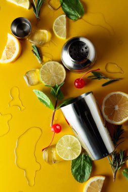 Kokteyl yapmak için malzemelerle karıştırıcı. Sarı arka plan. Üst görünüm.