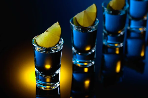 Tequila Mit Limettenscheiben Auf Schwarzem Reflektierendem Hintergrund Starkes Alkoholisches Getränk — Stockfoto