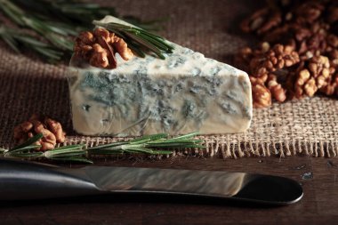 Eski ahşap bir masada cevizli ve biberiyeli mavi peynir..