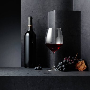 Siyah bir taş masada kırmızı şarap ve mavi üzüm. Boşluğu kopyala.