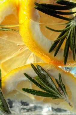 Limon dilimleri ve biberiyeli kokteyl cin toniği. Makro çekim.