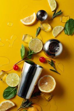 Kokteyl yapmak için malzemelerle karıştırıcı. Sarı arka plan. Üst görünüm.