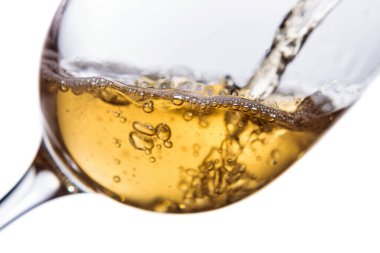 Beyaz arka planda izole edilmiş beyaz şarap kadehine dökülüyor.