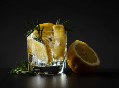 Siyah bir masada limonlu ve biberiyeli soğuk karbonatlı içecek..