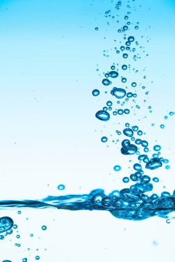 Mavi su, hava kabarcıklarıyla dalga yüzeyine vurur..