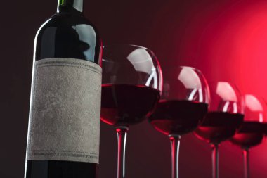 Şişe ve bir kadeh kırmızı şarap. Eski boş kağıt etiketi. Seçici odaklanma. Etiket için kaydedilmiş kırpma yolu.