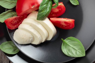 Siyah tabakta domatesli ve fesleğenli Mozzarella..